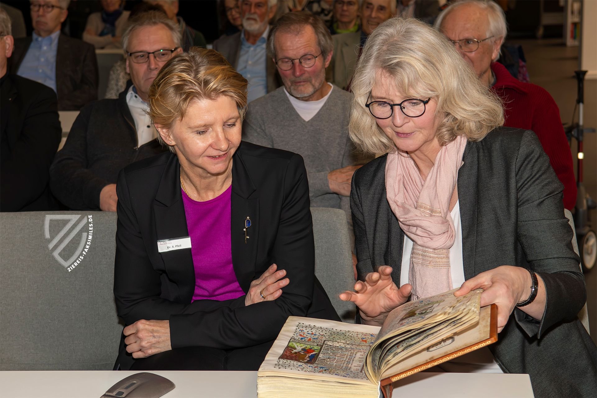 Die Leiterin der Handschriften- und Sondersammlung Frau Dr. Brigitte Pfeil-Amann (li.) und die Leitende Bibliotheksdirektorin Frau Claudia Martin-Konle blättern im mitgebrachten Faksimile des Rohan-Stundenbuchs